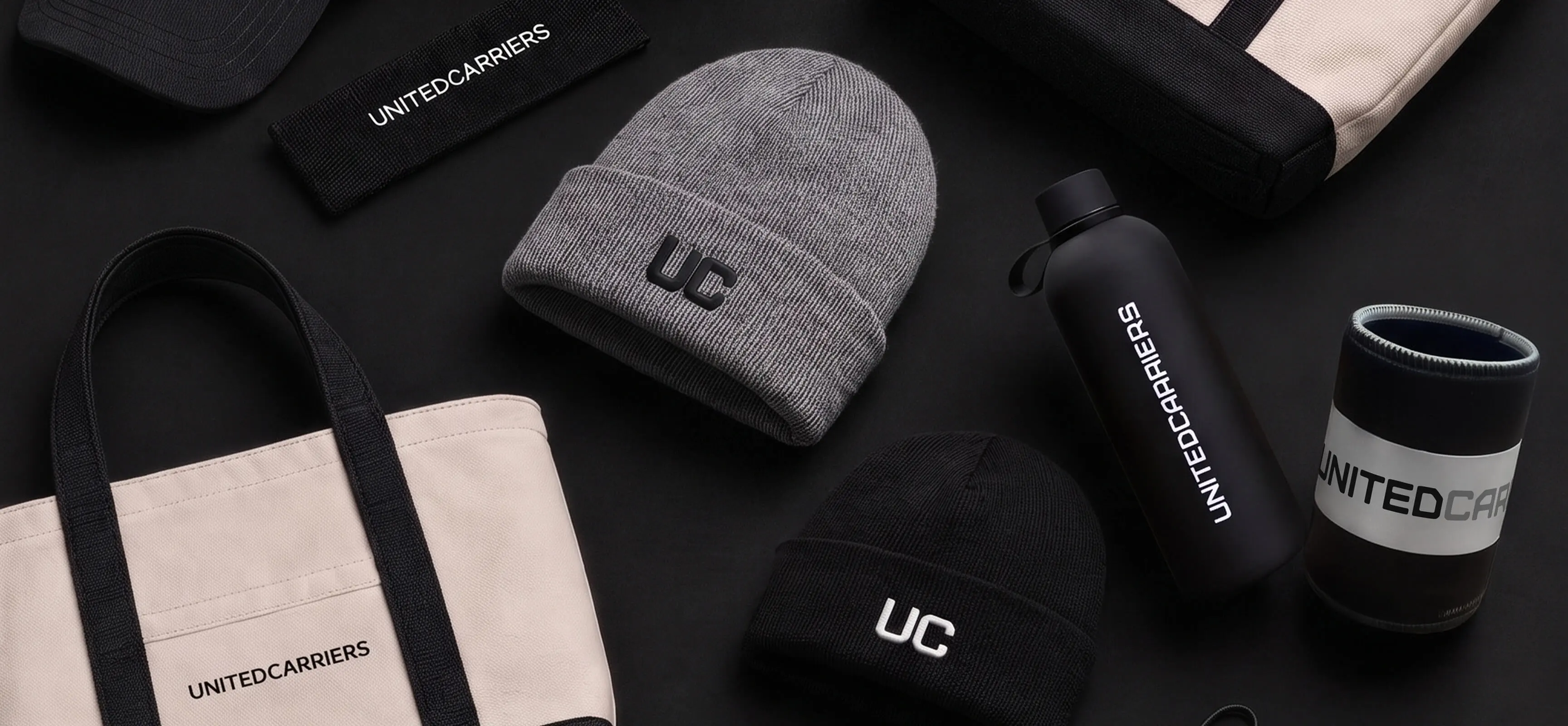Black and gray beanies, tote bags, water bottle, and sleeve featuring Brutelo Carriers branding.